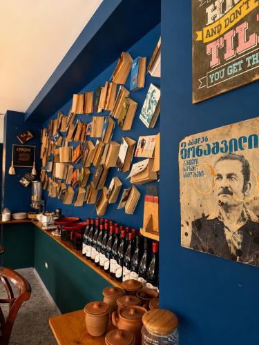 a blue wall with a shelf with bottles of wine at Chemodann Kazbegi in Kazbegi