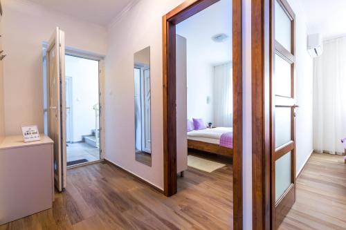 a room with a mirror and a bedroom with a bed at Aqualiget-Apartmanház E-Car plug-in point Szeged in Szeged