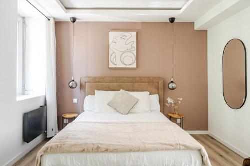 a bedroom with a large bed and two mirrors at L'Eden Spa - Jacuzzi - Saint-Etienne in Saint-Étienne