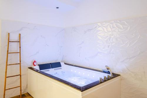 a bath tub in a room with a ladder at L'Eden Spa - Jacuzzi - Saint-Etienne in Saint-Étienne