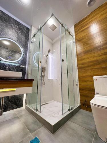 a bathroom with a shower with a sink and a toilet at ASR Plaza in Jizzax