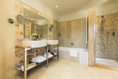 a bathroom with a sink and a shower and a tub at Hotel MR Les Rotes in Denia