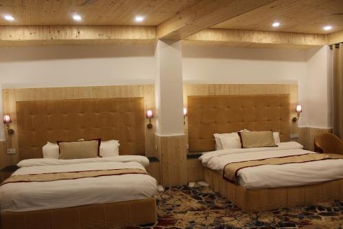 a room with two beds in a room at Hotel Yadu Vilas in Phata