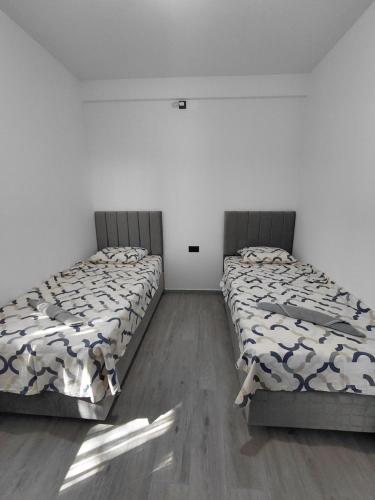 two beds sitting next to each other in a room at B&L Apartmani in Sutomore