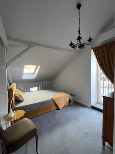 a bedroom with a bed and a chair and a window at Podróżnik in Oświęcim