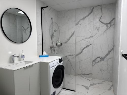 a bathroom with a washing machine and a shower at Tamula Panorama in Võru