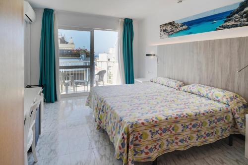 a hotel room with a bed and a balcony at Hotel Amic Can Pastilla in Can Pastilla