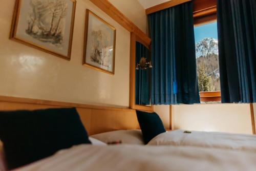 ein Hotelzimmer mit einem Bett und einem Fenster in der Unterkunft B&B Chalet Brigitte Hike & Bike in Arabba