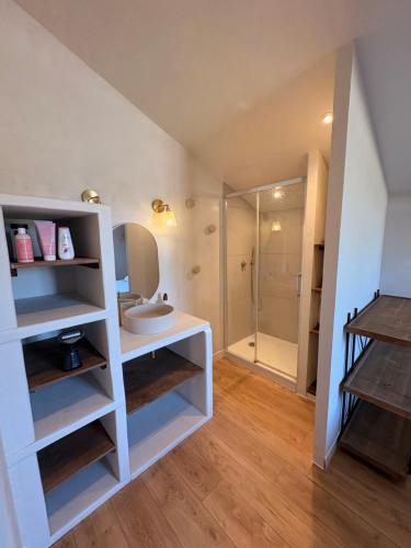 a bathroom with a white sink and a shower at La parenthèse in Lagrave
