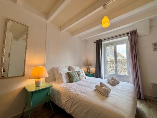 a bedroom with a large bed with a window at Samour House - Centre ville in Saint-Vaast-la-Hougue