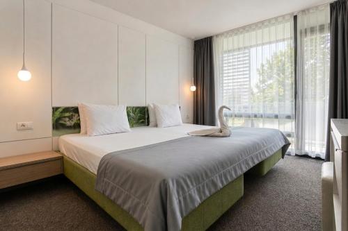 ein Schlafzimmer mit einem großen Bett und einem großen Fenster in der Unterkunft Hotel Melodia in Venus