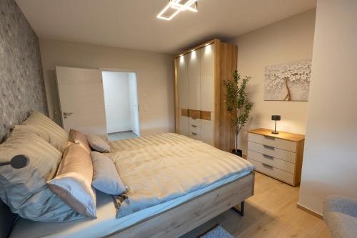 a bedroom with a large bed and a dresser at Ferienwohnnung EifelPanorama Berk in Dahlem