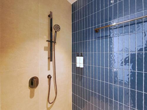 a bathroom with a shower with blue tiles at Bedz Hotel Ban Bueng in Ban Bung