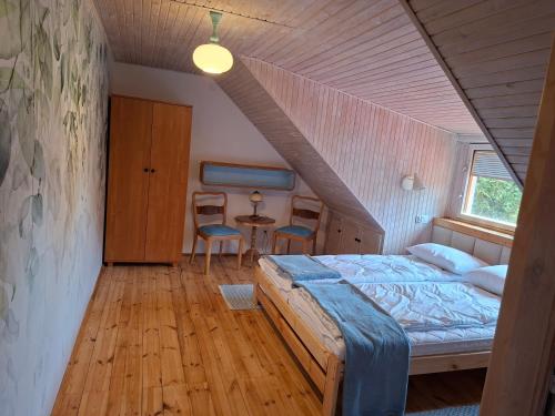 a bedroom with a bed and a table and chairs at Sielanka na Kociewiu in Skrzynia
