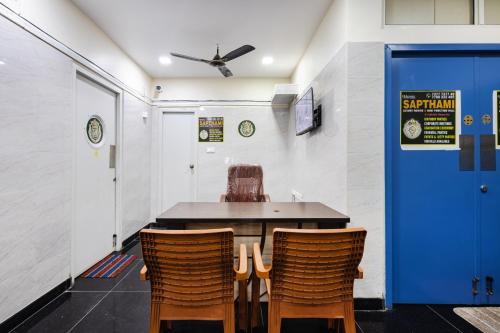 a table and chairs in a room with a blue door at Sapthami Luxury Rooms in Guntūr