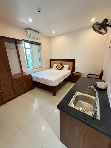 a bathroom with a sink and a bed in a room at LD Housing 9 in Ðống Thôn