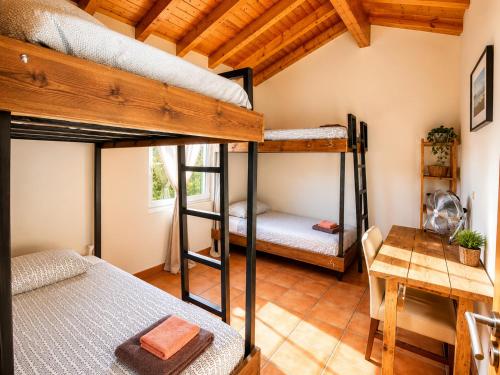 a room with two bunk beds and a desk at Mayla Surf House in Aljezur