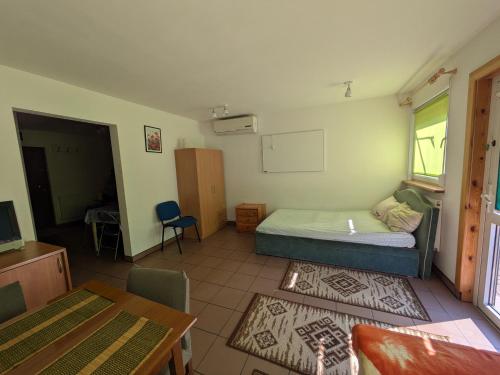 a small room with a bed and a table at Biały domek przy Hajnówce in Dubiny