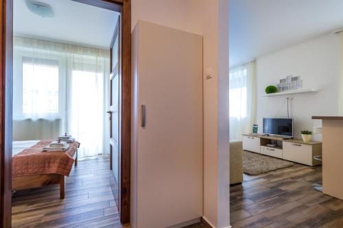 a bedroom with a bed and a television in a room at Aqualiget-Apartmanház E-Car plug-in point Szeged in Szeged