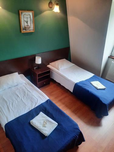 two beds in a small room withthritisthritisthritisthritisthritisthritisthritisthritisthritis at Dworek kwatery pracownicze in Kętrzyn