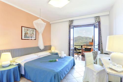 a hotel room with a bed and a balcony at Essence Isola d'Elba - Le Picchiaie Resort in Portoferraio
