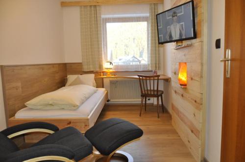 a living room with a couch and a tv on a wall at Bergfrieden Leutasch/Seefeld in Leutasch