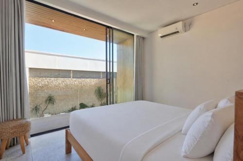 a bedroom with a white bed and a window at Casa Cemagi by Orivista-LUX 3BR Tropical, 2 Min to Beach in Cemagi
