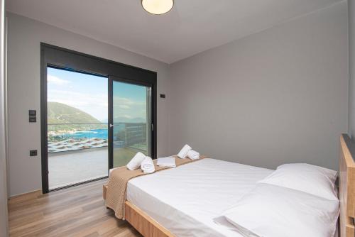 a bedroom with a bed and a large window at Aifantis Villa 2 in Póndi