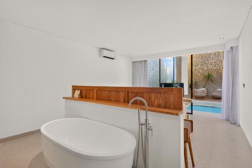 a bathroom with a tub and a toilet in a room at Casa Cemagi by Orivista-LUX 3BR Tropical, 2 Min to Beach in Cemagi
