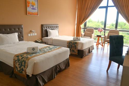 a hotel room with two beds and a table and chairs at Greenmont Hotel & Apartment in Bandar Seri Begawan