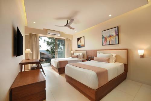 a hotel room with two beds and a window at Ayati Resort & Spa in Panchgani