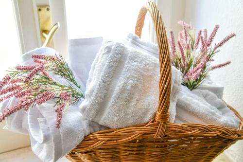 ein Korb mit Handtüchern und Blumen auf einem Tisch in der Unterkunft Le Sciosce in San Giorgio Lucano