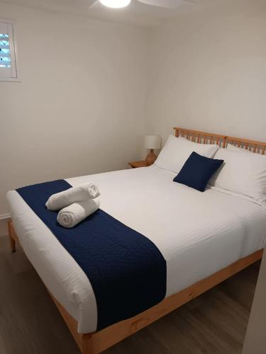 a bedroom with a bed with two towels on it at Oceanfront Ground Floor Apartment - Dwell 3 in Bargara in Bargara