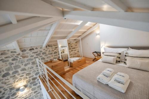 a bedroom with a large bed in a attic at Calais Boutique Apartments in Hydra