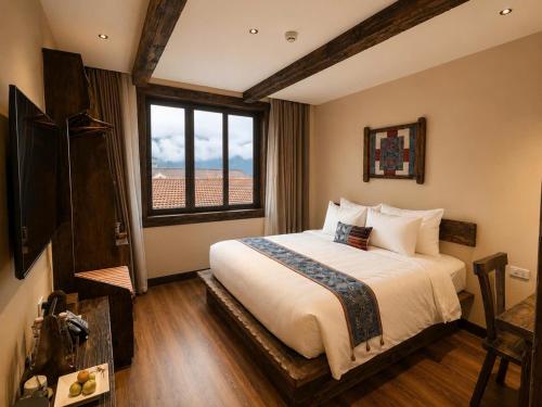 a bedroom with a large bed and a large window at The Mysteri Sapa in Sapa