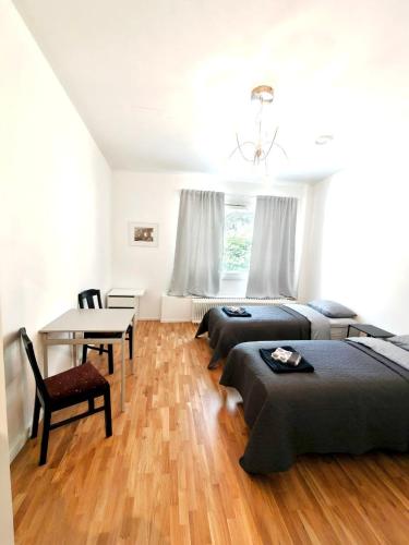 a bedroom with three beds and a desk and a table at Reipas Ekonom Accommodation in Kotka