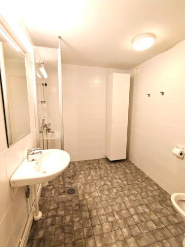 a white bathroom with a sink and a shower at Reipas Ekonom Accommodation in Kotka