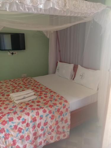 a small bedroom with a bed with a canopy at La Quinta Lodge in Mwanza