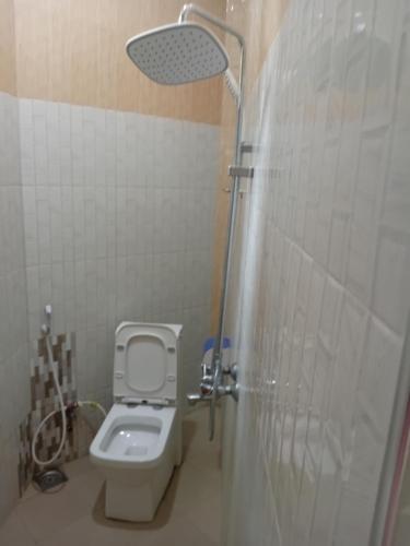 a small bathroom with a toilet and a shower at La Quinta Lodge in Mwanza