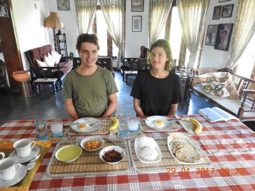 two people sitting at a table with breakfast food at Serenity in Kandy