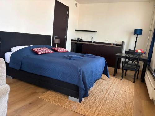 a bedroom with a blue bed and a sink at Logement Sylroede in Lemmer