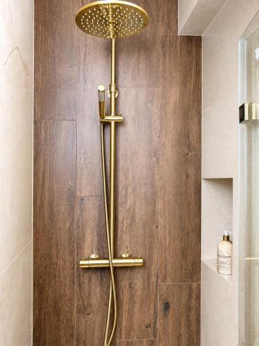 a shower with a gold fixture on a wall at Majowe Sagankowo 1 minuta od Krupówek in Zakopane