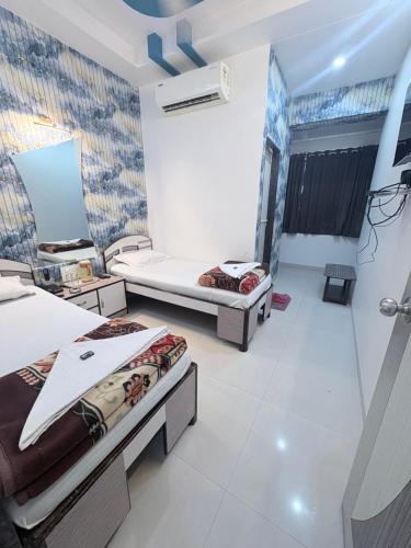a bedroom with two beds and a wall with a mural at Hotel Broadway Colaba in Mumbai