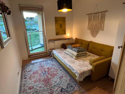 a living room with a couch and a window at Rooms in an Apartment with Beautiful Views in Przemyśl