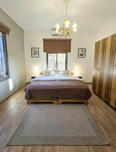 a bedroom with a large bed and a chandelier at Maison des Couleurs in Aley