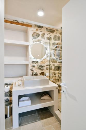 a bathroom with a white sink and a mirror at Calais Boutique Apartments in Hydra