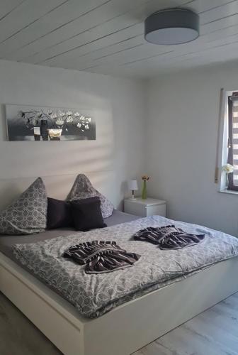 a bed in a white room with avertisementatron at Moderne, ruhige Ferienwohnung! in Geistingen