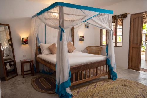 a bedroom with a bed with a canopy at Villa Kiota in Paje