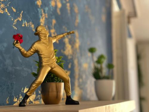 eine goldene Statue eines Mannes, der eine rote Rose hält in der Unterkunft BrameL Suite in Lamezia Terme