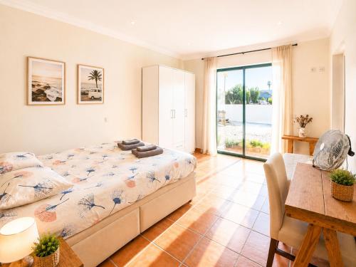 a bedroom with a bed and a table and a desk at Mayla Surf House in Aljezur
